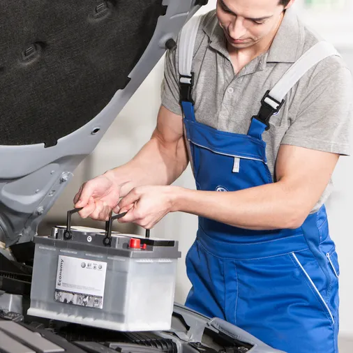 A mechanic replacing a VW battery.